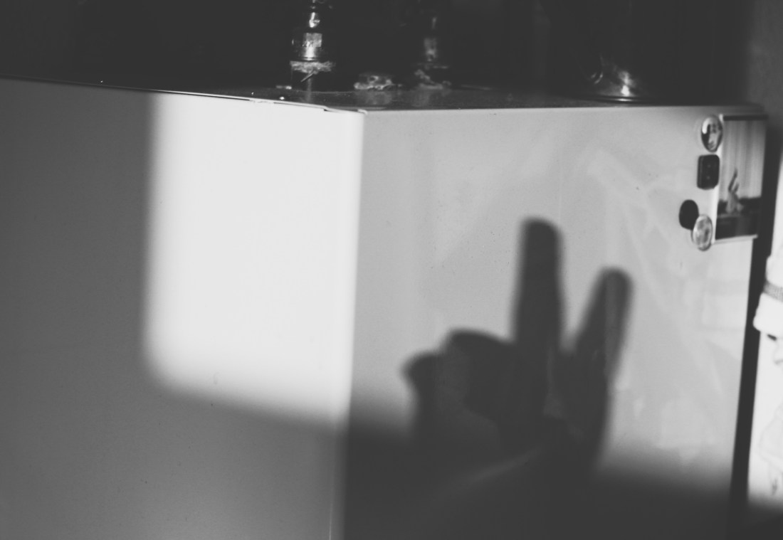 Schwarz-weiß Bild, Schatten einer Hand auf weißem Metalkörper