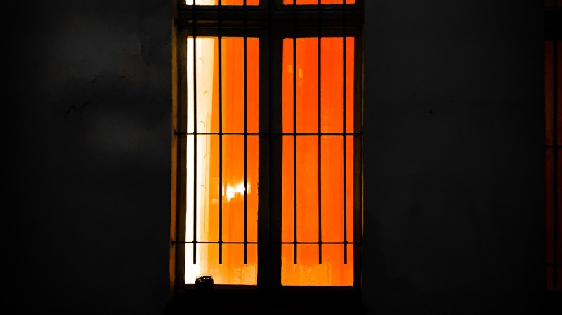 hell erleuchtetes Fenster mit Gittern davor