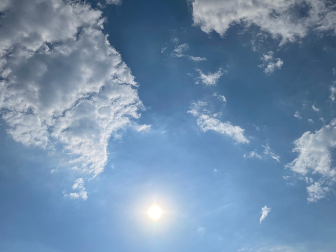 Himmel mit Wolken, die die Sonne einrahmen
